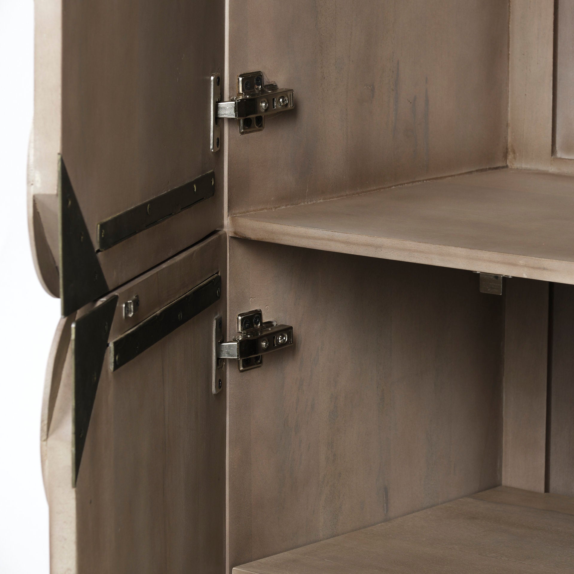 Three-quarter perspective view of the Excelsior II storage cabinet featuring a light brown wood finish, a decorative scalloped motif on the doors, and a gold iron X-base