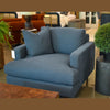 Alternative showroom view showcasing the industrial concrete table paired with a modern blue fabric lounge chair