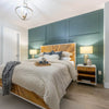 Lifestyle shot featuring the Casablanca bed styled with neutral bedding against a deep teal paneled wall