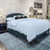 Lifestyle shot of the Moxie bed styled with crisp white bedding in a modern industrial suite with exposed brick walls