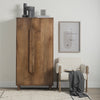 Lifestyle shot featuring the Astrid armoire styled with minimalist decor and a neutral armchair in a bright modern interior