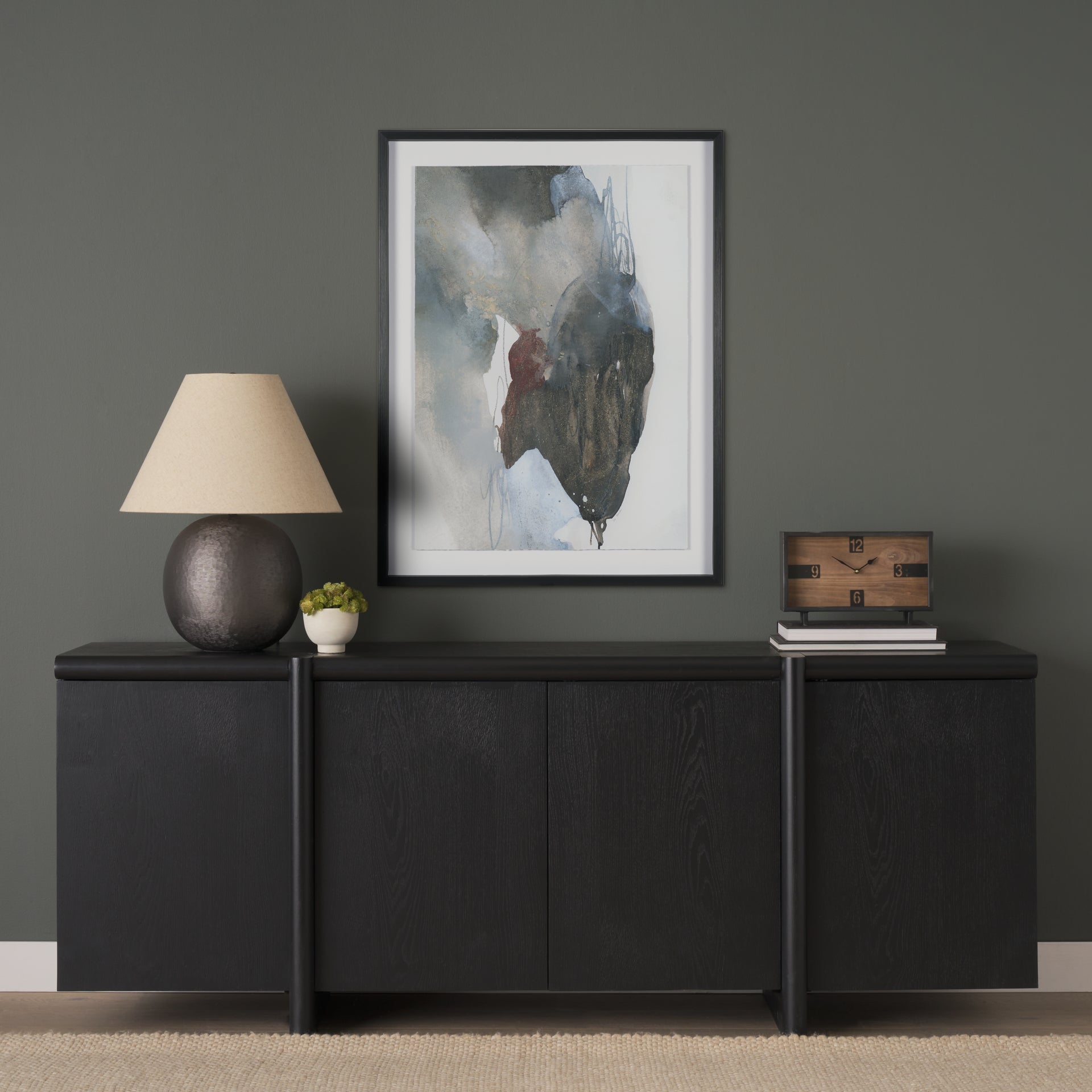 Lifestyle shot of the black oak sideboard styled with a large abstract painting and a neutral table lamp in a modern setting