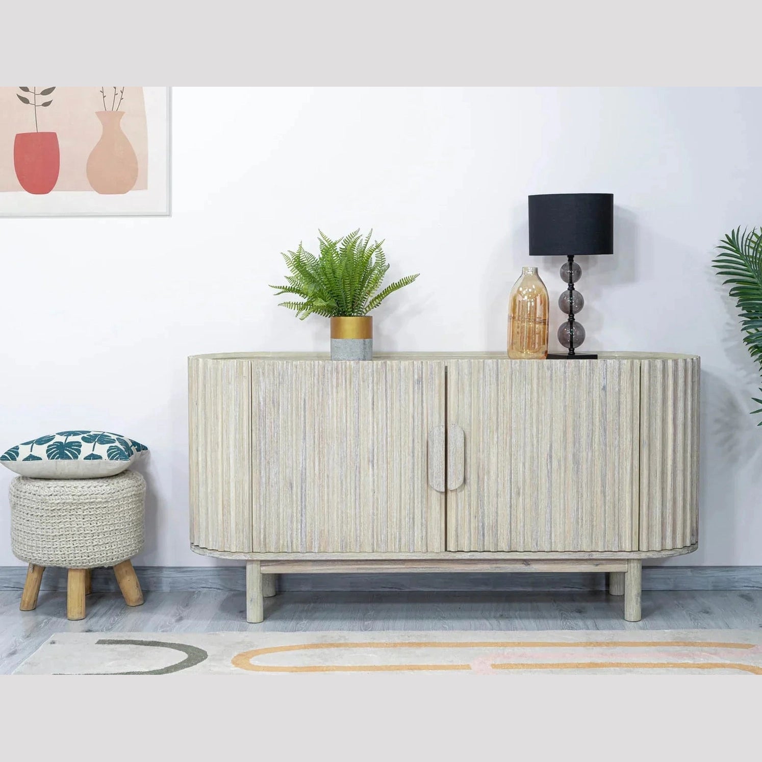 Front perspective view of the Oasis 4-door sideboard featuring a light oak finish, rounded corners, and vertical matte black metal handles