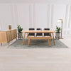 Lifestyle shot featuring the sideboard styled in a full dining room set with a matching natural wood table and black chairs