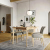 Lifestyle perspective of the Kenzo table styled with high-back grey chairs under a modern pendant light