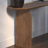 Lifestyle shot highlighting the console table styled against a neutral wall with a designer book and architectural plant