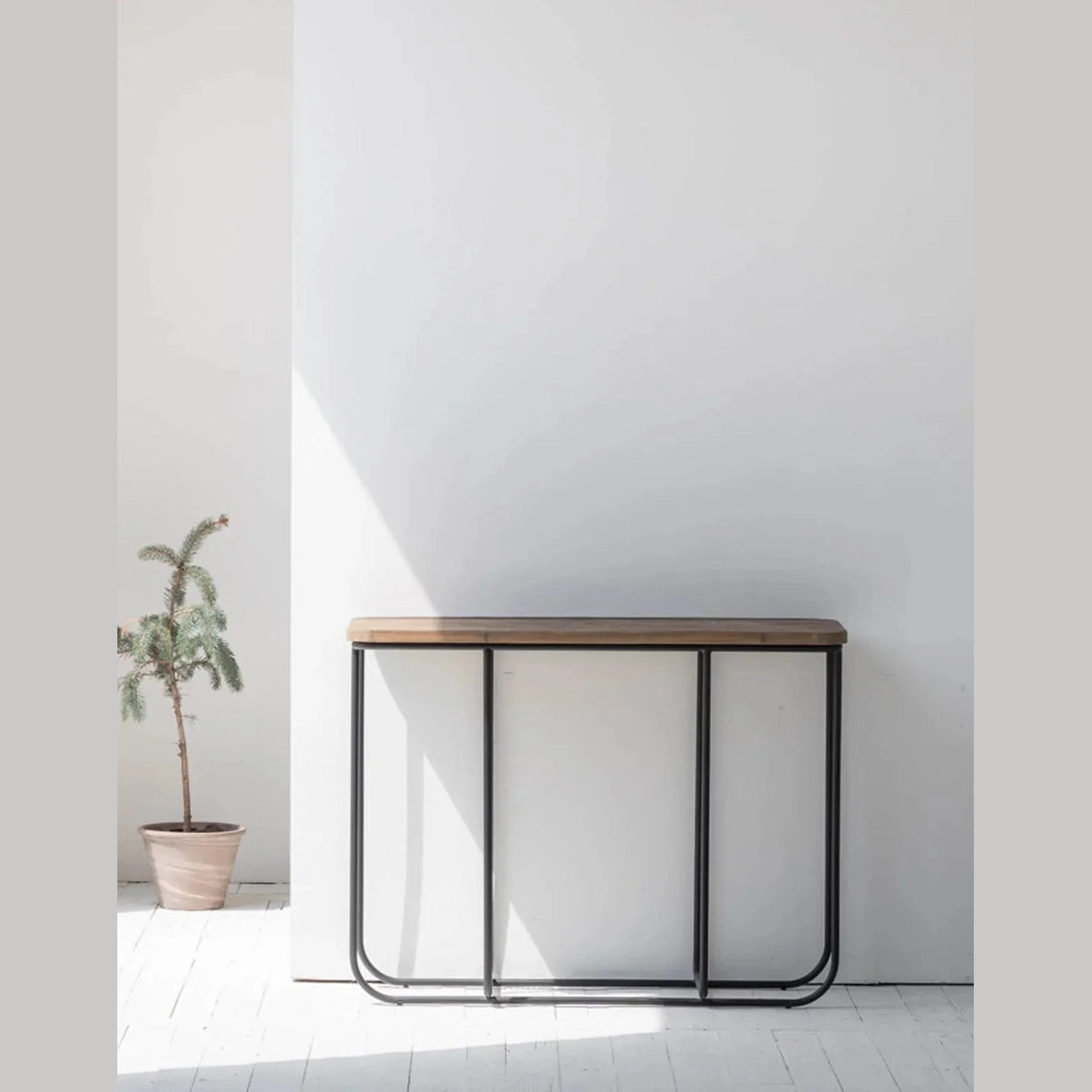 Wide lifestyle view showcasing the narrow console table styled against a clean white wall in a modern home