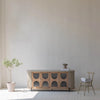 Wide-angle lifestyle shot showcasing the oval credenza as a statement piece in an airy modern interior