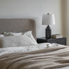 Perspective lifestyle view highlighting the soft architectural curves of the headboard against a minimalist white wall