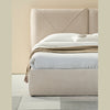 Low-angle lifestyle shot focusing on the rounded upholstered base styled with a textured tan throw blanket