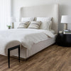Lifestyle shot of the Aino bed styled with olive green accents and a black minimalist bench in a bright bedroom