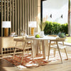 Lifestyle shot featuring the Alaia sideboard styled in a bright covered patio dining area with a matching round wood table and modern chairs