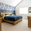 High-angle lifestyle shot showcasing the bed in a contemporary room with coordinating blue patterned wallpaper