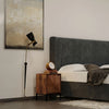 Wide lifestyle shot showcasing the Nikita nightstand paired with a matching wood bed frame in a bright, sunlit master suite
