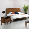 Studio lifestyle shot showcasing the Allure bed alongside a matching walnut nightstand and minimalist decor