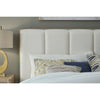 Close-up shot focusing on the soft cotton upholstery texture and the clean vertical channel tufting of the headboard