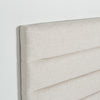 Close-up shot highlighting the soft tactile texture of the cream upholstery and the precision of the horizontal tufted seams