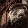 D-Bodhi Knut basket side table with wooden lid open, storing a white blanket