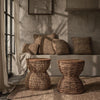 Lifestyle image showing the Rebana Alto table styled in a cozy bohemian interior with neutral tones and natural materials