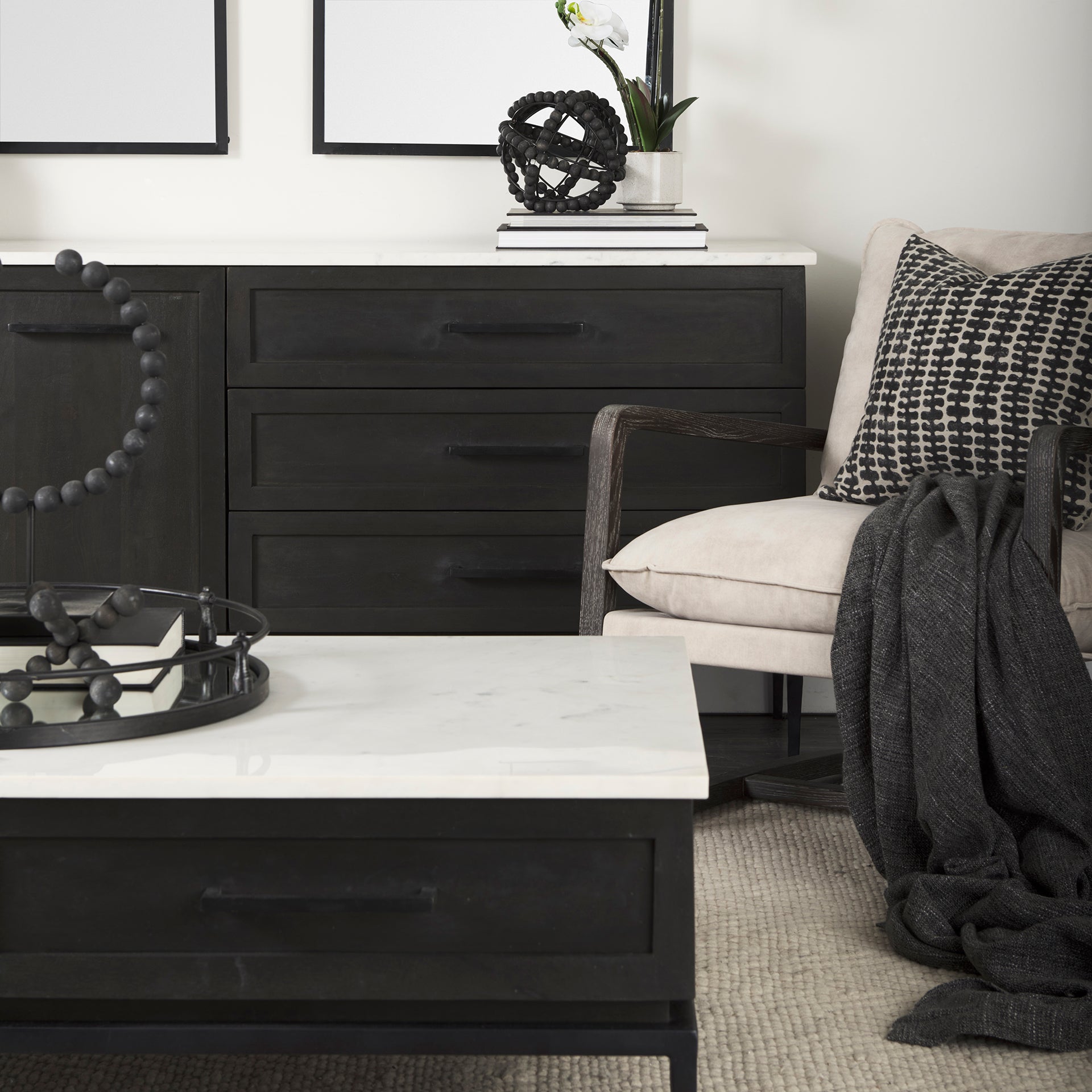Front perspective view of the Gemma sideboard featuring a dark charcoal wood finish, a white marble top, and slim black metal legs