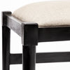 Extreme close-up shot focusing on the textured dark taupe fabric upholstery and the high-quality joinery of the black wooden frame