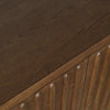 Macro shot focusing on the tactile vertical ridges and the deep natural wood grain of the dark oak fluted door panels