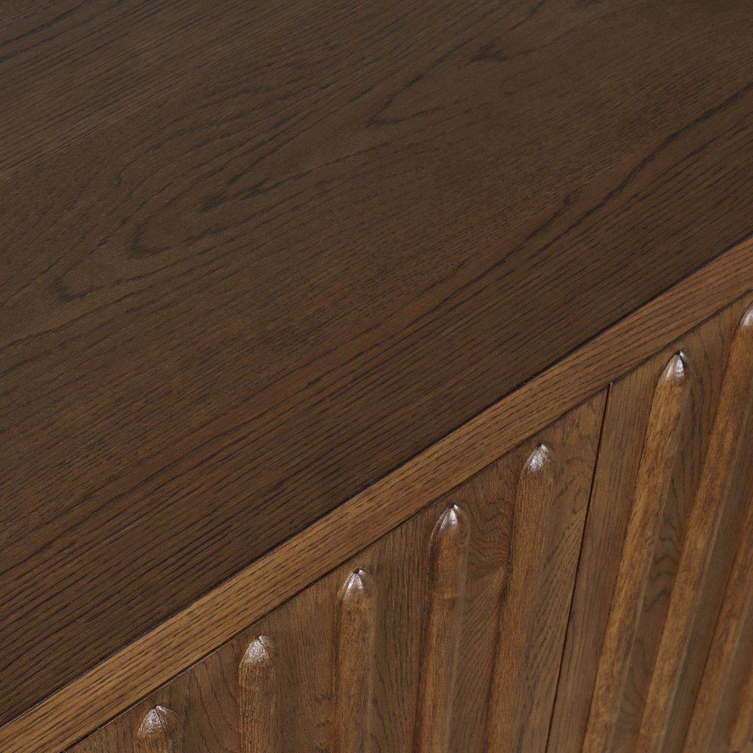 Front perspective view of the Skap 4-door sideboard in a dark oak finish featuring vertical fluted door panels and a matching plinth base