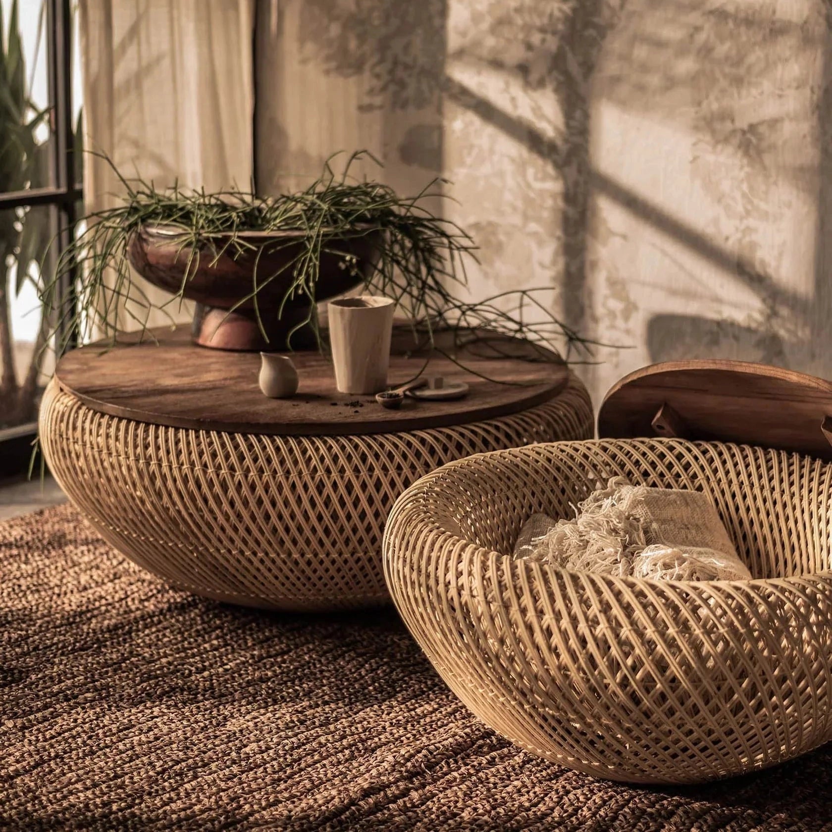 Front view of the large D-Bodhi Wave coffee table featuring a rounded woven abaca base in a natural finish with a solid recycled wood tabletop