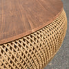 Close-up perspective focusing on the textured edge of the circular recycled wood top resting on the intricate abaca weave