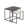 Front view of the Dharma nesting table set featuring a black marble top on the larger table and a white marble top on the smaller nesting table with black metal frames