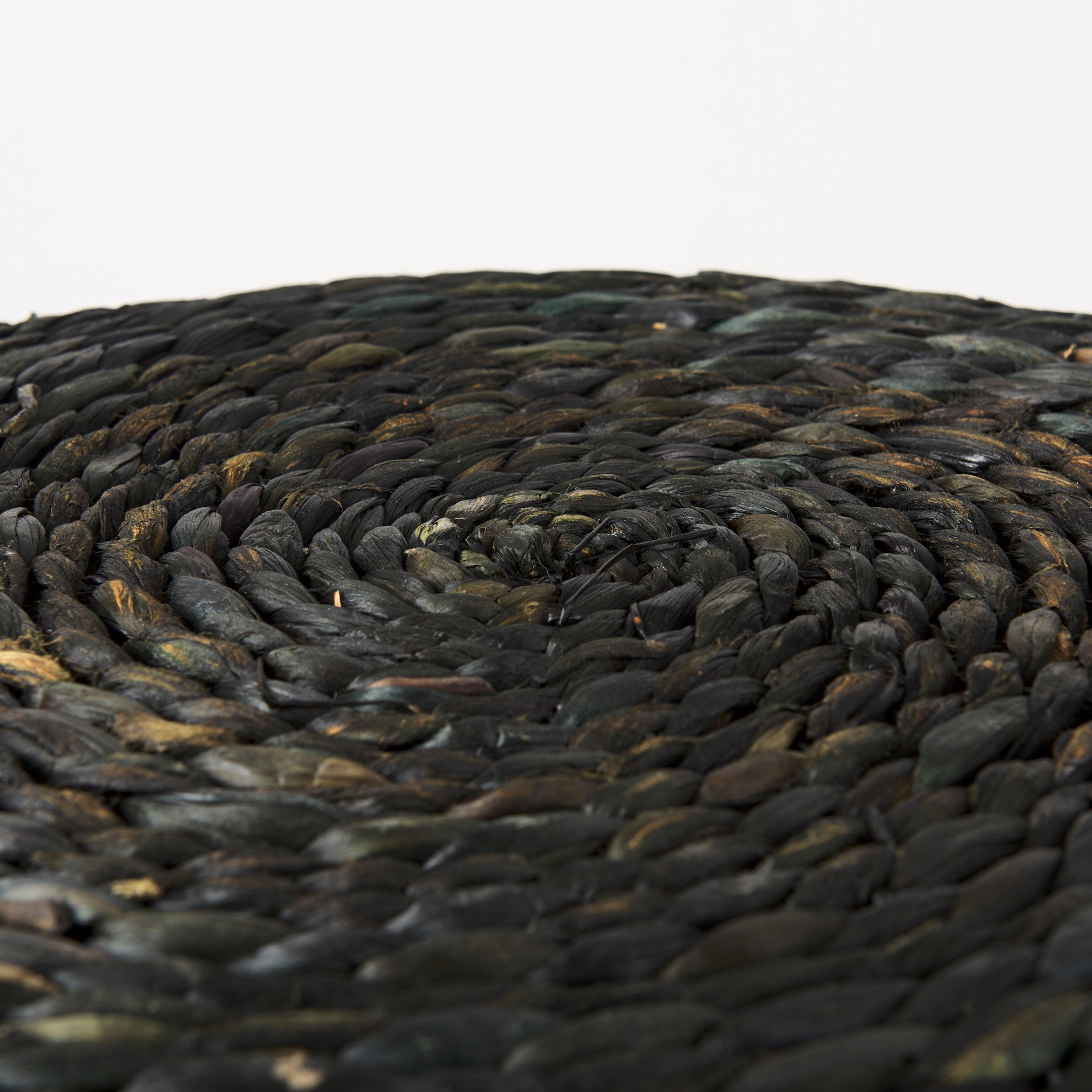 Macro detail shot showcasing the intricate texture and organic variations of the black dyed water hyacinth and cornhusk fibers