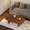 Wide lifestyle view of the coffee table centered in a light-filled living space with a grey sectional sofa