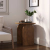 Lifestyle shot of the Domingo table styled in a sunlit corner with a white armchair and green foliage