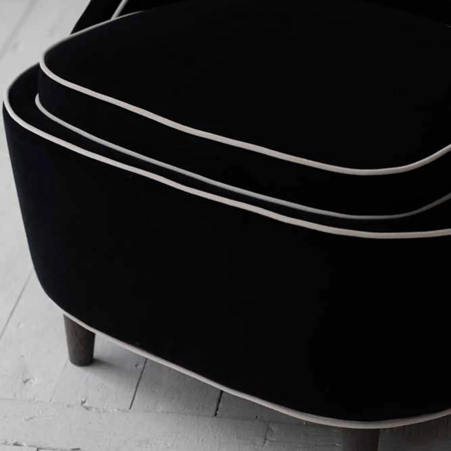 Close-up of the low-profile dark tapered wood legs supporting the sculpted frame