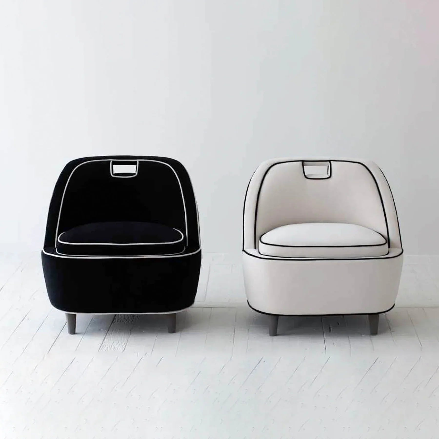 A pair of Ebony chairs in black and cream styled together in a minimalist studio