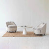 Black and cream Ebony chairs positioned around a unique tri-leg wood coffee table
