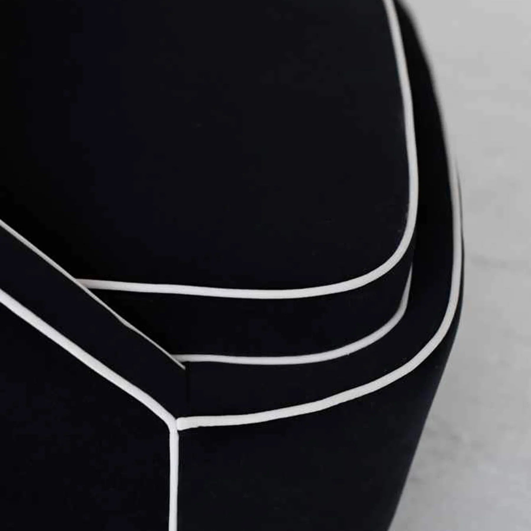 Detailed view of the precision stitching and curved lines on the black velvet frame