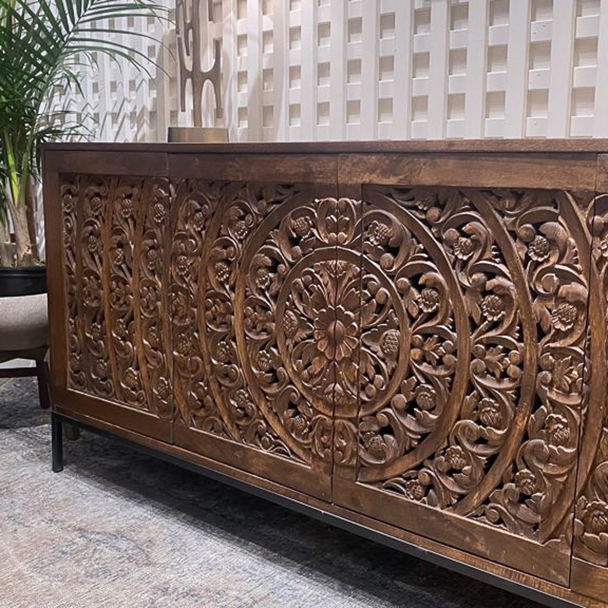 Straight-on front view of the Carved sideboard featuring a rich natural wood finish and intricate floral mandala carvings across four doors