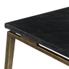 Close-up shot focusing on the thin square black marble slab and the architectural gold metal joinery at the corner