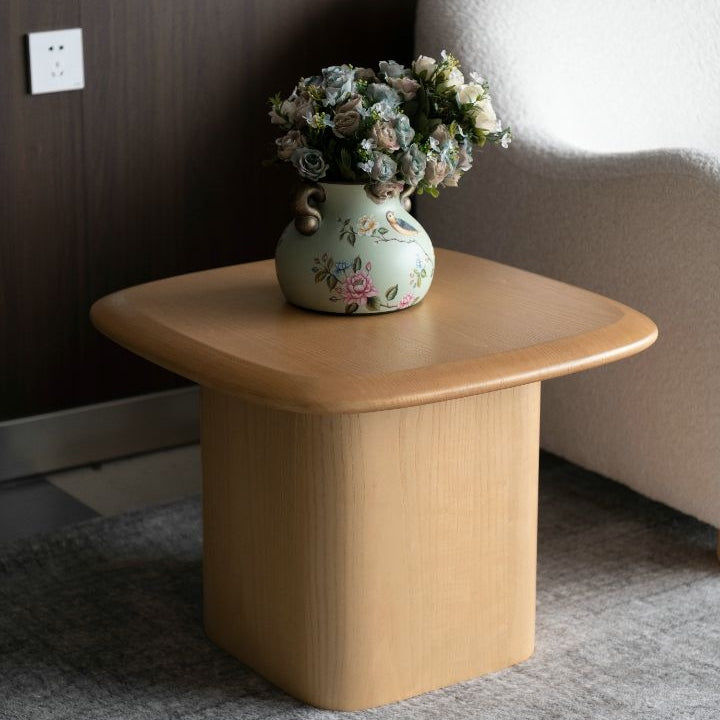 Side-angle lifestyle view showing the Ekera table styled in a contemporary interior next to a light-colored sofa