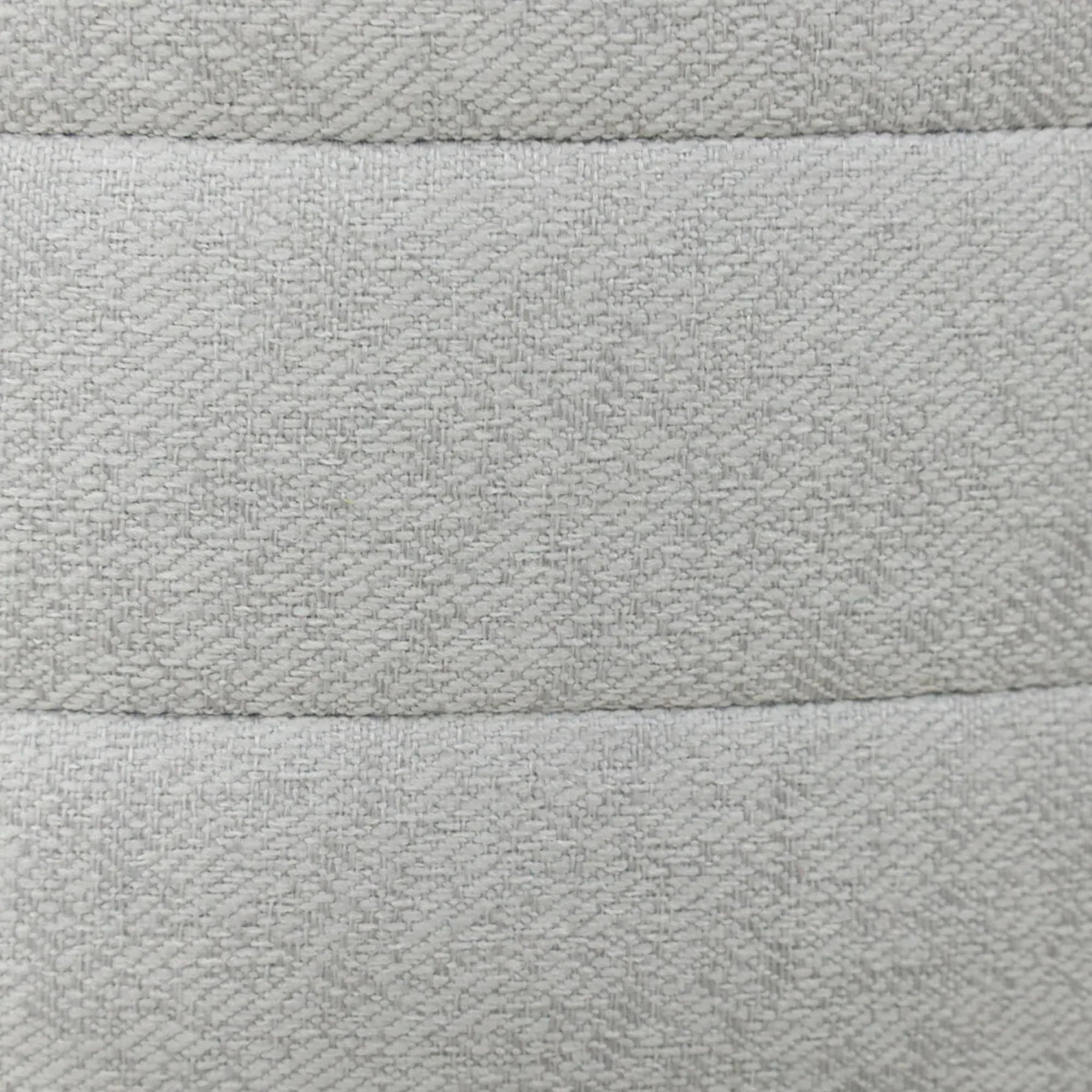 Front view of the Elio cylindrical storage ottoman featuring platinum gray textured fabric and horizontal channel stitching