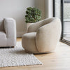 Side-angle lifestyle shot of the Estelle chair demonstrating its soft, curved lines in a contemporary home environment.