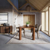 Alternate lifestyle shot showcasing the table in a bright modern space with large windows and neutral decor
