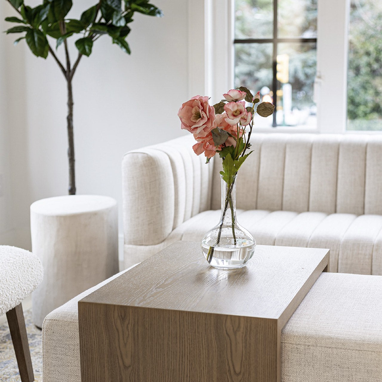 Front view of the Forest coffee ottoman featuring a cream upholstered rectangular bench with a nested blonde oak waterfall table