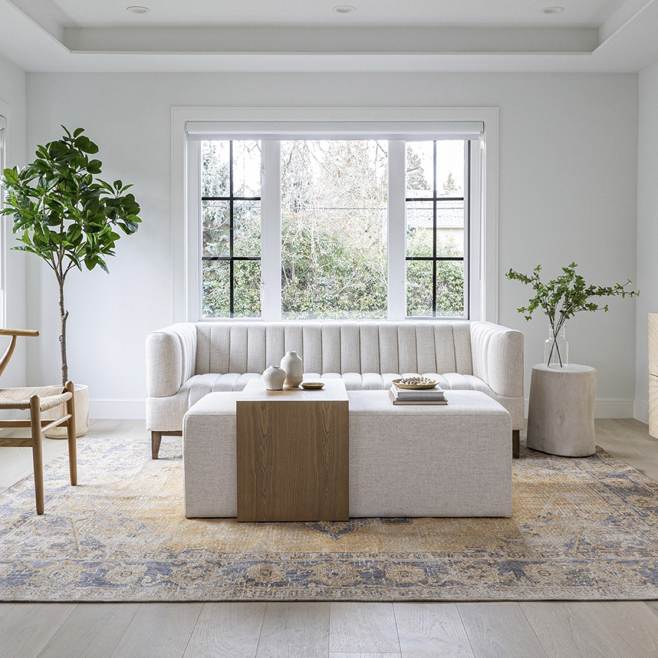 Front view of the Forest coffee ottoman featuring a cream upholstered rectangular bench with a nested blonde oak waterfall table