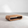Lifestyle view of the Form curve table styled in a bright minimalist setting with a clean concrete floor