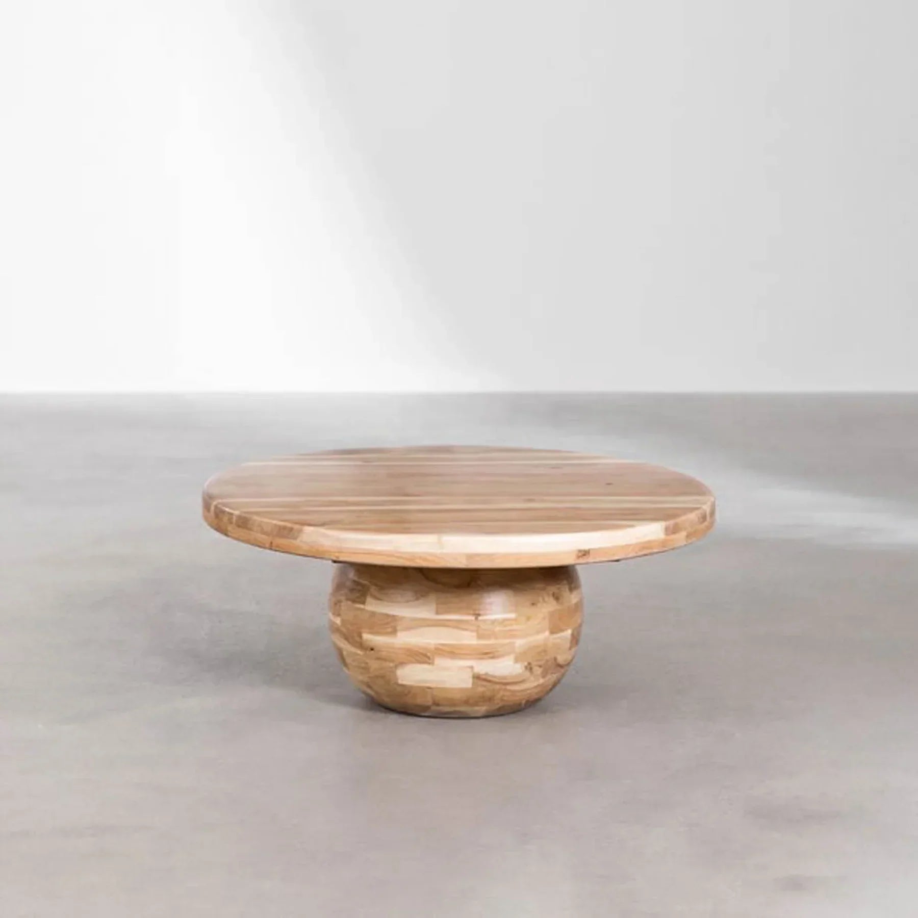 Lifestyle shot of the Form sphere coffee table styled in a minimalist space with a light grey floor