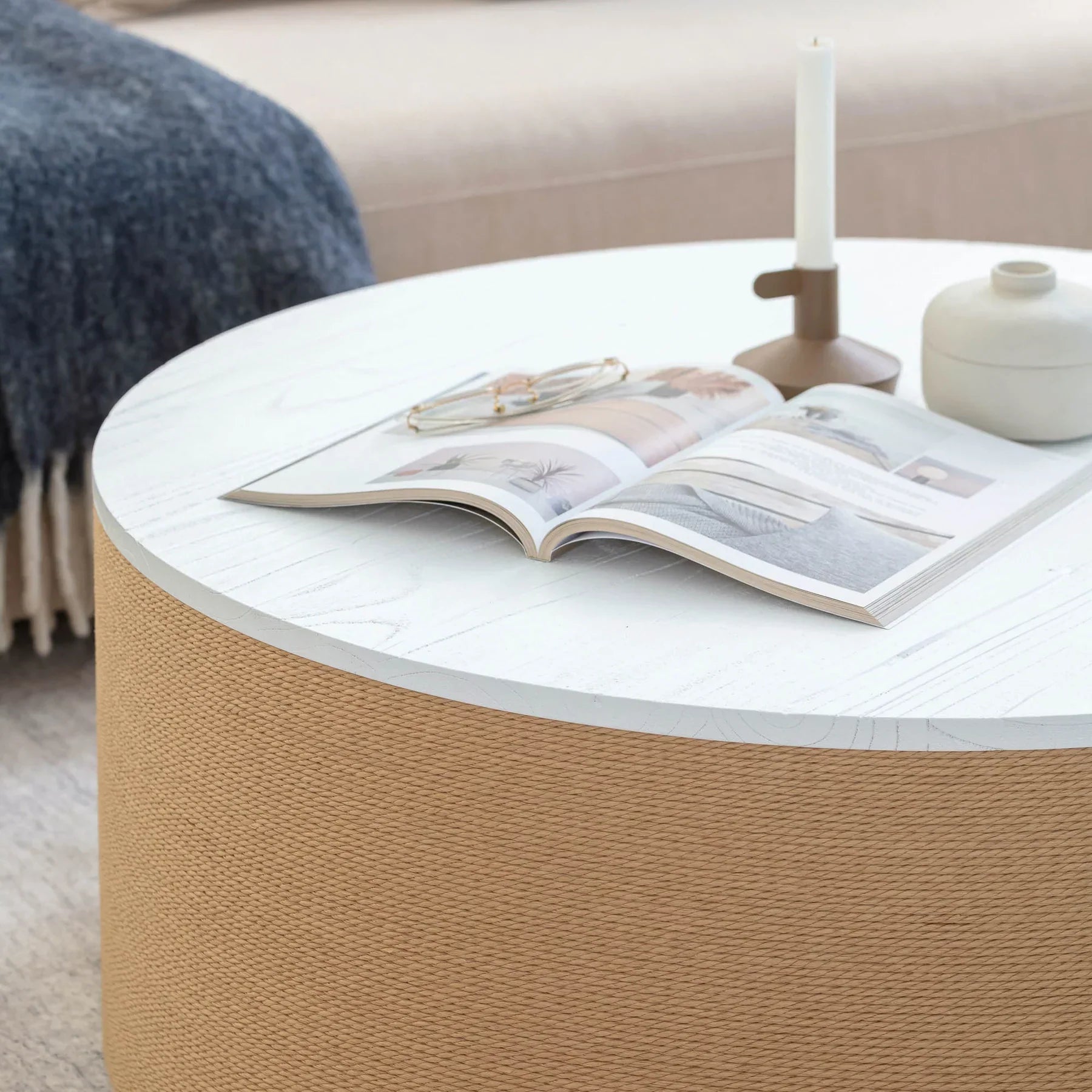 Front view of the Fresco coffee table featuring a circular white wood top and a drum-style base wrapped in natural tan jute fiber