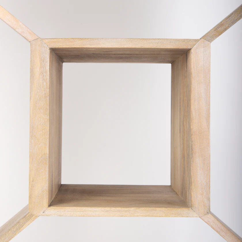 Three-quarter perspective view of the Traro shelving unit in blonde wood featuring a unique geometric honeycomb compartment design