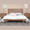 Studio lifestyle shot featuring the cognac-finished nightstand styled with a coordinating bed and pink accent pillows